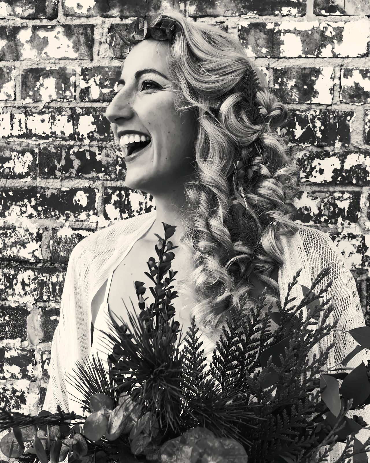 Smiling bride with cascading curls and bouquet